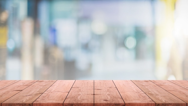 Piano del tavolo in legno vuoto e caffetteria sfocata e sfondo interno del ristorante - può essere utilizzato per visualizzare o montare i tuoi prodotti.