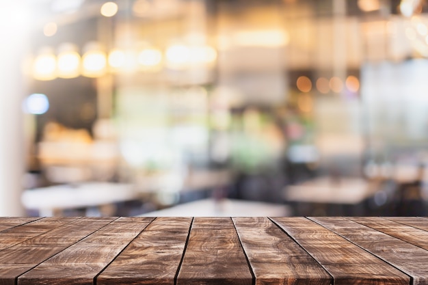 Piano d'appoggio in legno vuoto e interni sfocati della caffetteria e del ristorante