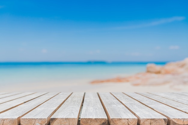 Empty wood table top and blurred summer beach background.