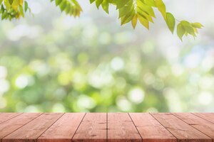 Empty wood table top and blurred view from green tree garden bokeh background.