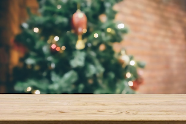 Empty wood table top with abstract blur decorated Christmas tree with baubles