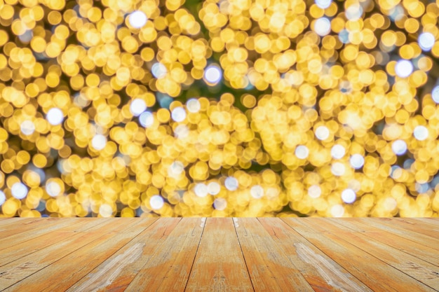 明るい背景のボケ味を持つぼかしクリスマス ツリーと空の木製テーブル トップ