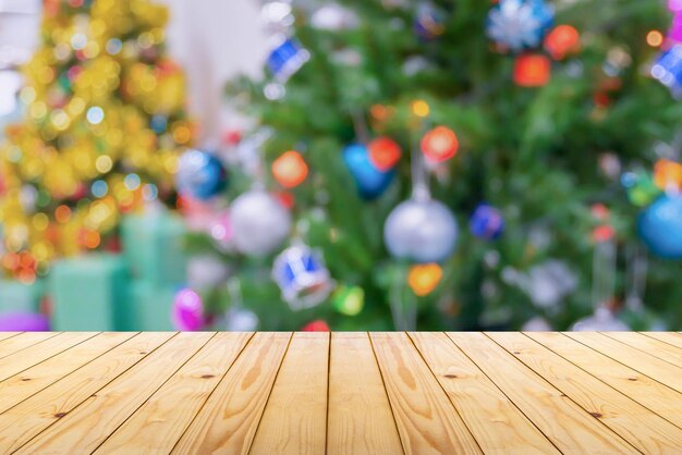 Empty wood table top with blur christmas tree with bokeh light background