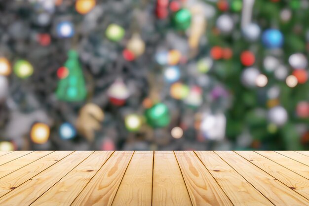 写真 ボケの明るい背景のぼんやりしたクリスマスツリーの空の木製のテーブルトップ