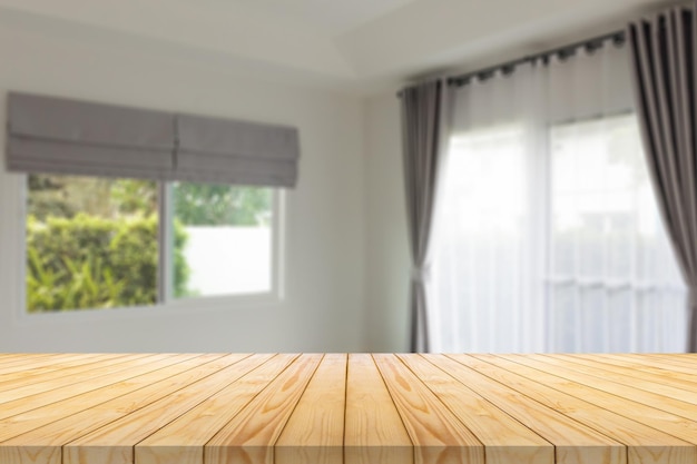 Empty wood table top with blur room interior with window\
curtain background