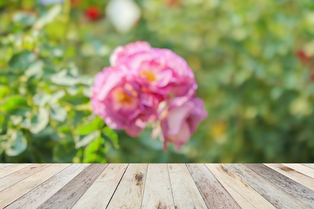 製品ディスプレイのためのバラ色のバラ園の背景の空の木製のテーブルトップ
