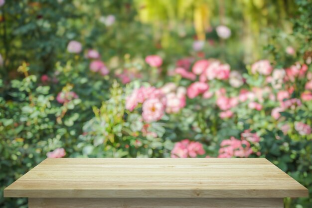 製品ディスプレイのためのバラ色のバラ園の背景の空の木製のテーブルトップ