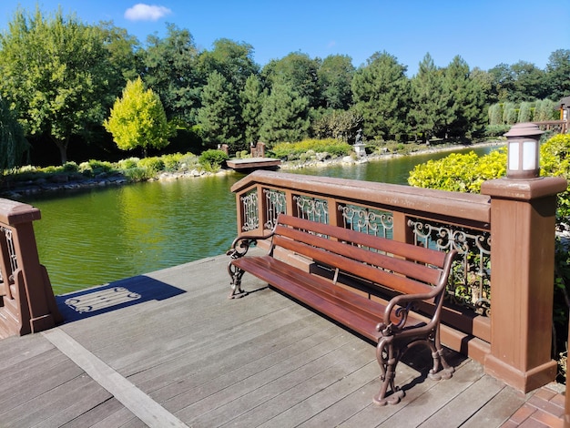 An empty wooden bench stands in a Park near the river embankment