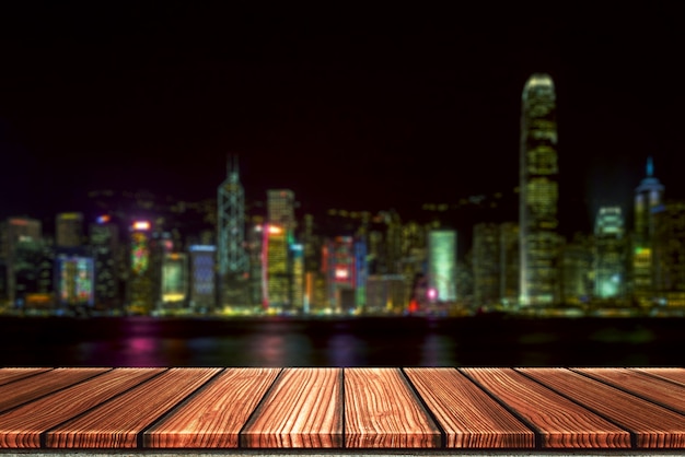 Empty Wooden board top table in front of night city blurred background.