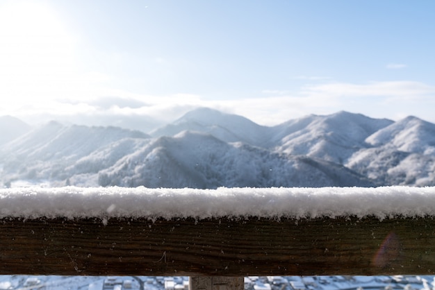 Фото Пустой деревянный стол сверху перед размытым снежным горным видом