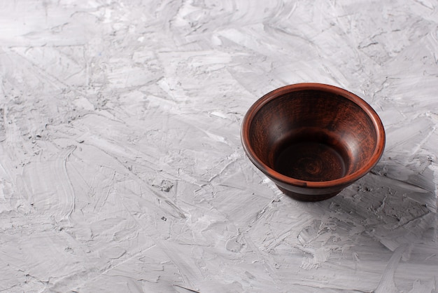 Empty wooden bowl on concrete background
