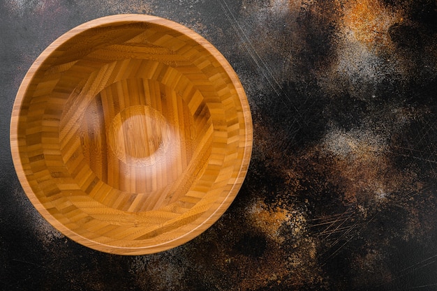 Фото Пустая деревянная миска с копией пространства для текста или еды, плоская планировка, вид сверху, на старом темном деревенском фоне стола