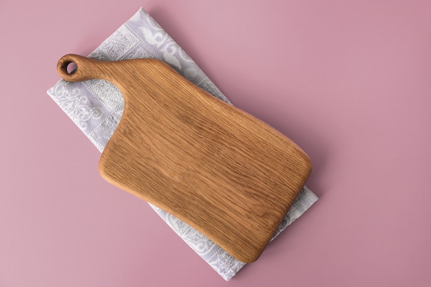 Empty wooden cutting board on cotton napkin