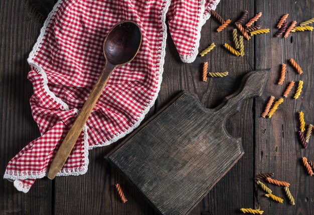 Empty wooden cutting board, wooden spoon on a red towel