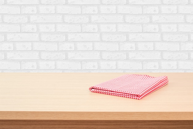 Empty wooden deck table with tablecloth over white brick wallpaper background. Perfect for product montage display