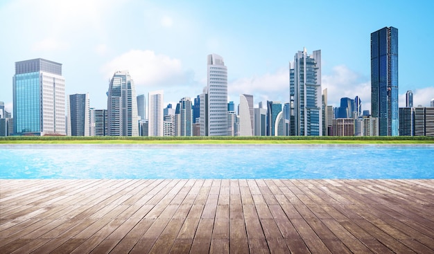 Empty wooden deck with swimming pool Beautiful pool side view with city skyline