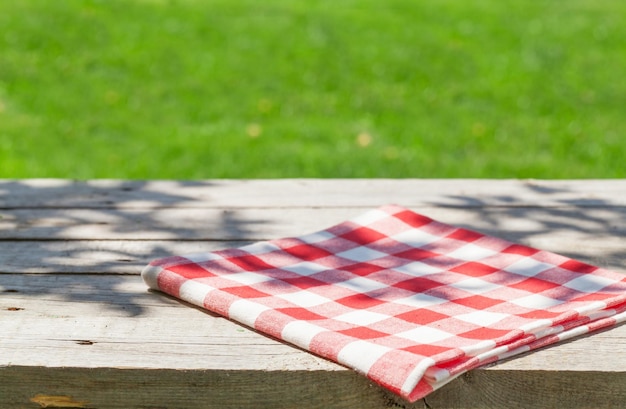 Empty wooden garden table with tablecloth