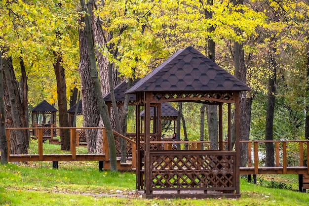 Foto gazebi in legno vuoti nel parco cittadino in una giornata autunnale senza persone