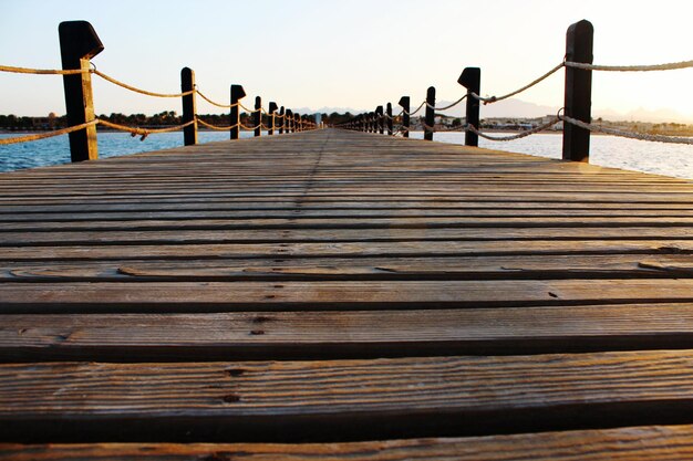 Foto un molo di legno vuoto in mare durante il tramonto