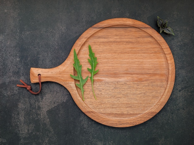 Photo empty wooden pizza platter set up on dark concrete. pizza tray on dark concrete background flat lay and copy space.