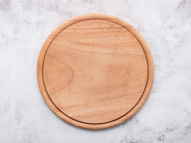 Empty wooden pizza platter set up on white concrete. Pizza board on white concrete background flat lay and copy space.