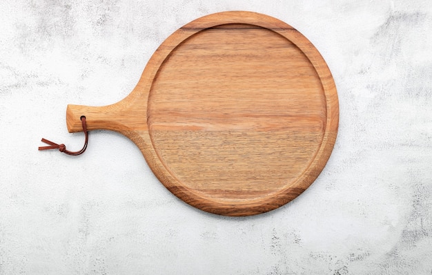 Empty wooden pizza platter set up on white concrete. Pizza board on white concrete background flat lay and copy space.