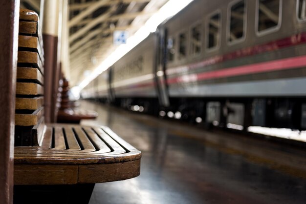 Foto sedile di legno vuoto sulla piattaforma della stazione ferroviaria