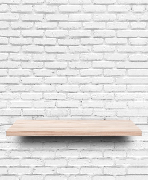 Empty wooden shelf on white brick wall background.