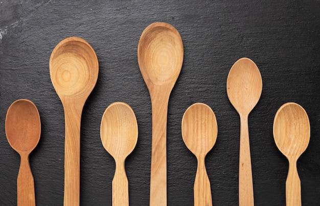 Empty wooden spoons on a a black background, top view, set