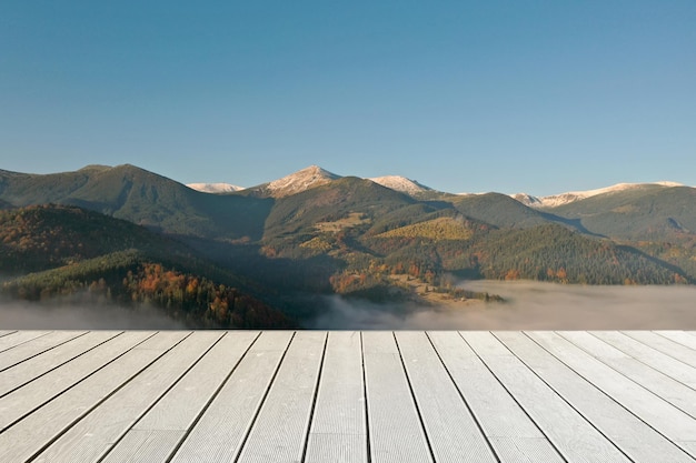 Empty wooden surface and beautiful view of landscape with thick mist in mountains