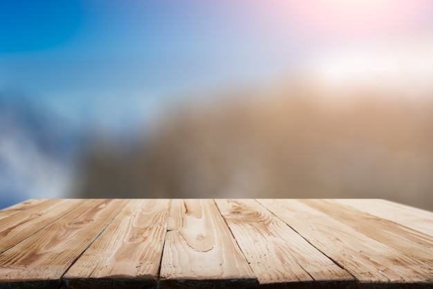 Empty wooden surface on bokeh background of snowy mountainous area on winter day