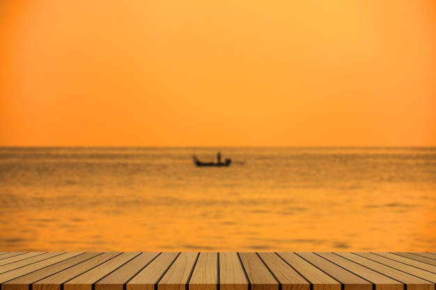 Empty wooden table on beautiful blurred sea sunset