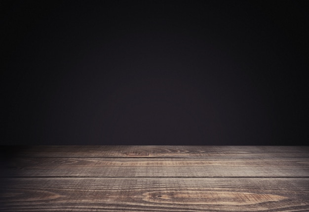 Empty wooden table on black background