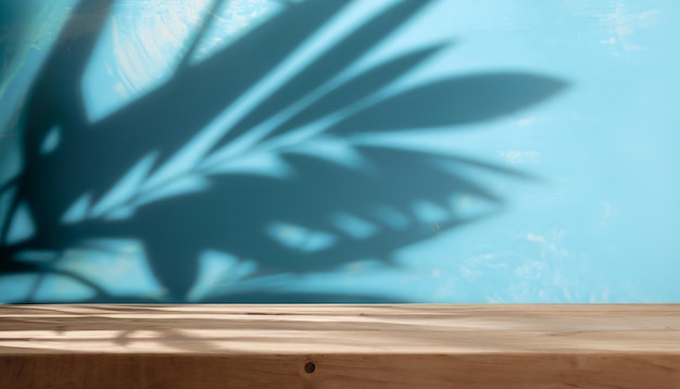 Empty wooden table on blue color wall background Background with shadows of leaves on the wall