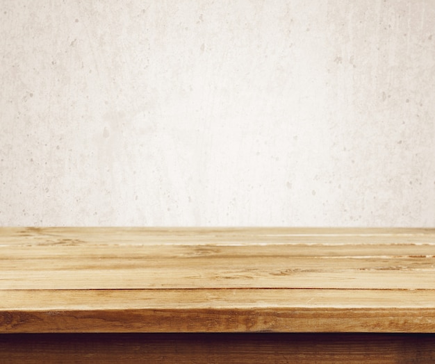 Пустой деревянный стол над коричневой цементной стеной гранж, винтаж, фон, шаблон