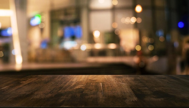 empty wooden table in front of abstract blurred background of coffee shop can be used for display mock up of product