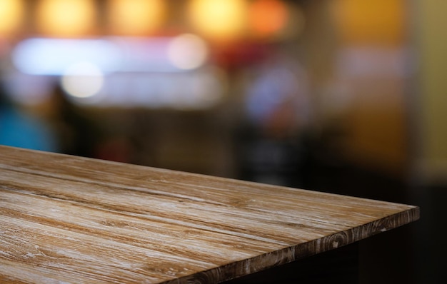 커피숍의 추상적인 흐릿한 배경 앞에 있는 빈 나무 테이블은 제품을 표시하거나 몽타주하는 데 사용할 수 있습니다. 제품 표시를 위해 Mock up