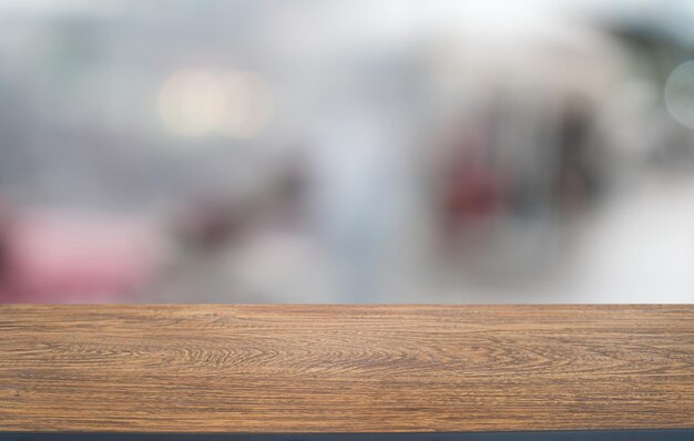 Foto un tavolo di legno vuoto di fronte allo sfondo sfocato astratto della caffetteria può essere utilizzato per visualizzare o montare i vostri prodotti mock up per la visualizzazione del prodotto