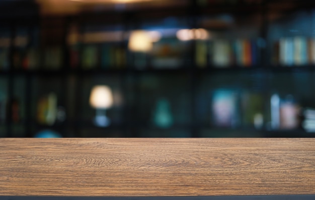 Empty wooden table in front of abstract blurred background of coffee shop