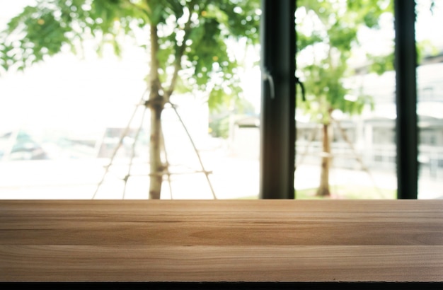 レストランの抽象的なぼやけた背景の前に空の木製のテーブル。あなたの製品を表示またはモンタージュするために使用することができます。カウンターの表示のためにモックアップします。