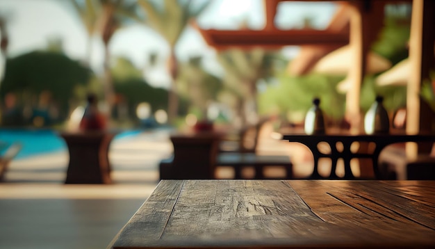 Empty wooden table in front of blurred pool resort