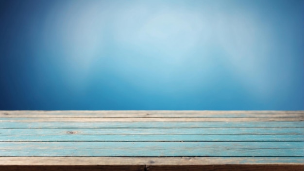 Empty wooden table in front with blurred blue background