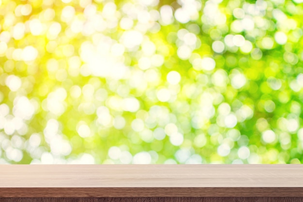 Photo empty wooden table for product placement or montage and green boken blurred background.