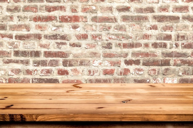 Foto tavolo in legno vuoto per l'inserimento o il montaggio del prodotto con particolare attenzione allo sfondo del muro di mattoni del piano del tavolo