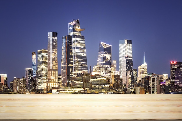 Empty wooden table top with beautiful New York skyscrapers at evening on background mock up