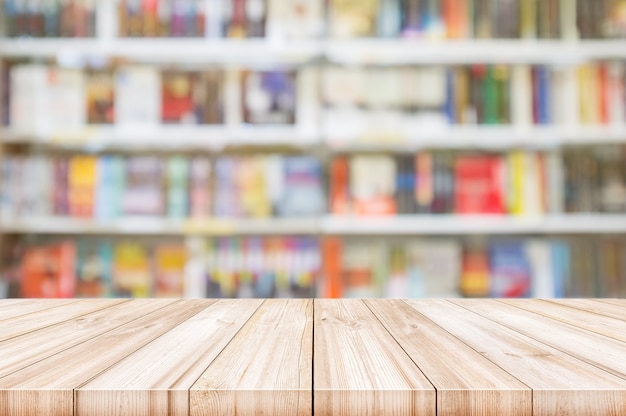 Photo empty wooden table top with blur bookshelves in bookstore background.