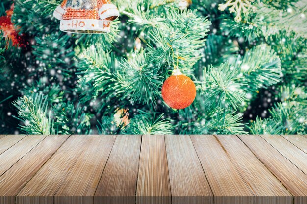 Empty wooden table top with blurred Christmas tree background