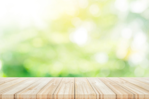 Empty wooden table top with blurred green garden background. 