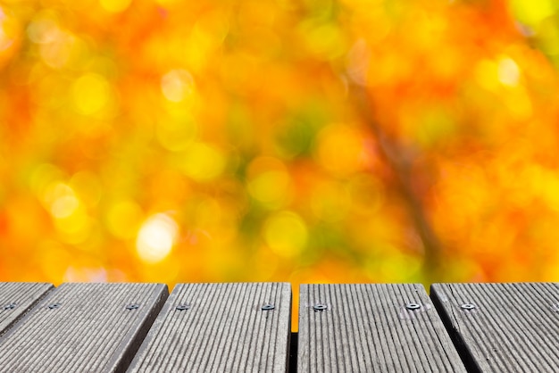 Foto piano d'appoggio di legno vuoto con colore variopinto del bokeh del giardino per creare.