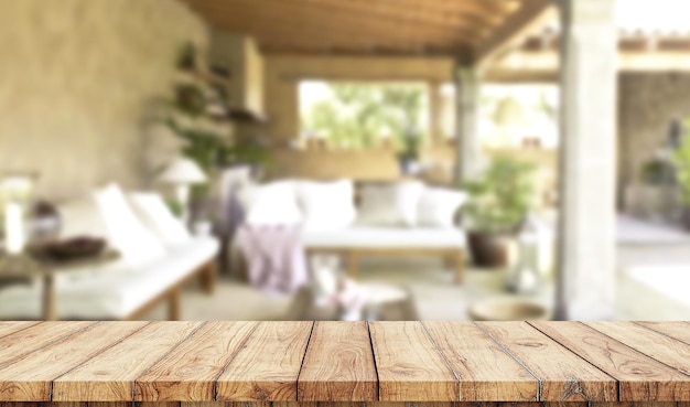 背景にスイミングプールとぼやけた豪華な庭と空の木製テーブル